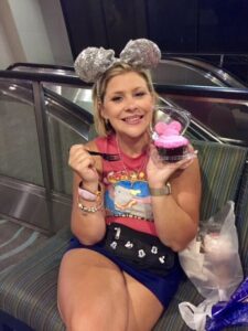 Lauren hersey at Disney World eating a cupcake wearing a dumbo outfit with silver mouse ears