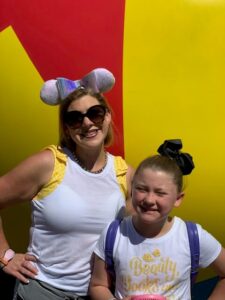 Lauren Hersey with daughter at Disney World wearing matching Beauty and the Beast outfits and white mouse ears