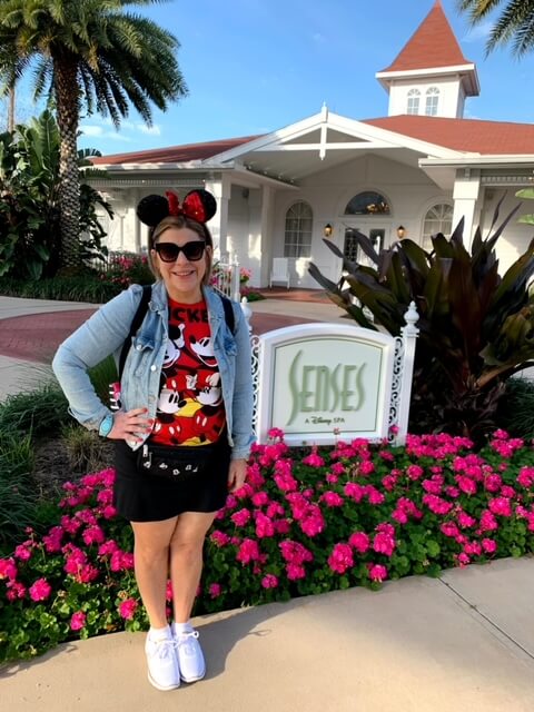 Lauren Hersey at Grand Floridan Spa wearing Disney outfit, jean jacket, sunglasses, classic mouse ears and fannypack