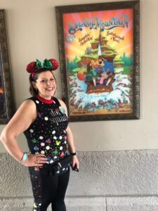 Lauren Hersey at Disney World in Magic Kingdom wearing Disney outfit with red and green mouse ears